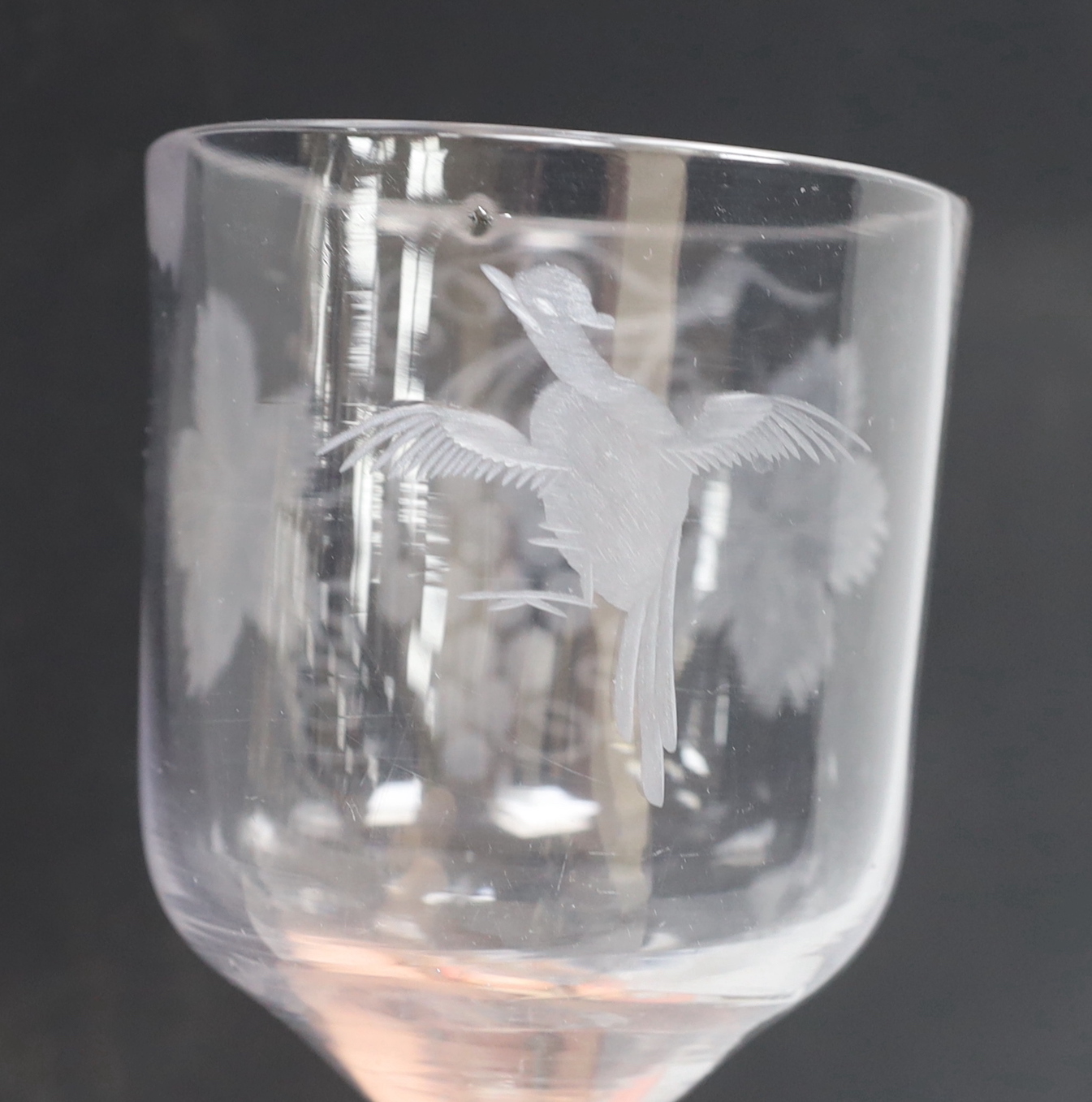 An English lead crystal goblet, c1740-50, ogee bowl with tool marks, engraved fruiting vines and a bird, with a plain stem, conical foot and rough pontil, 19.4cm